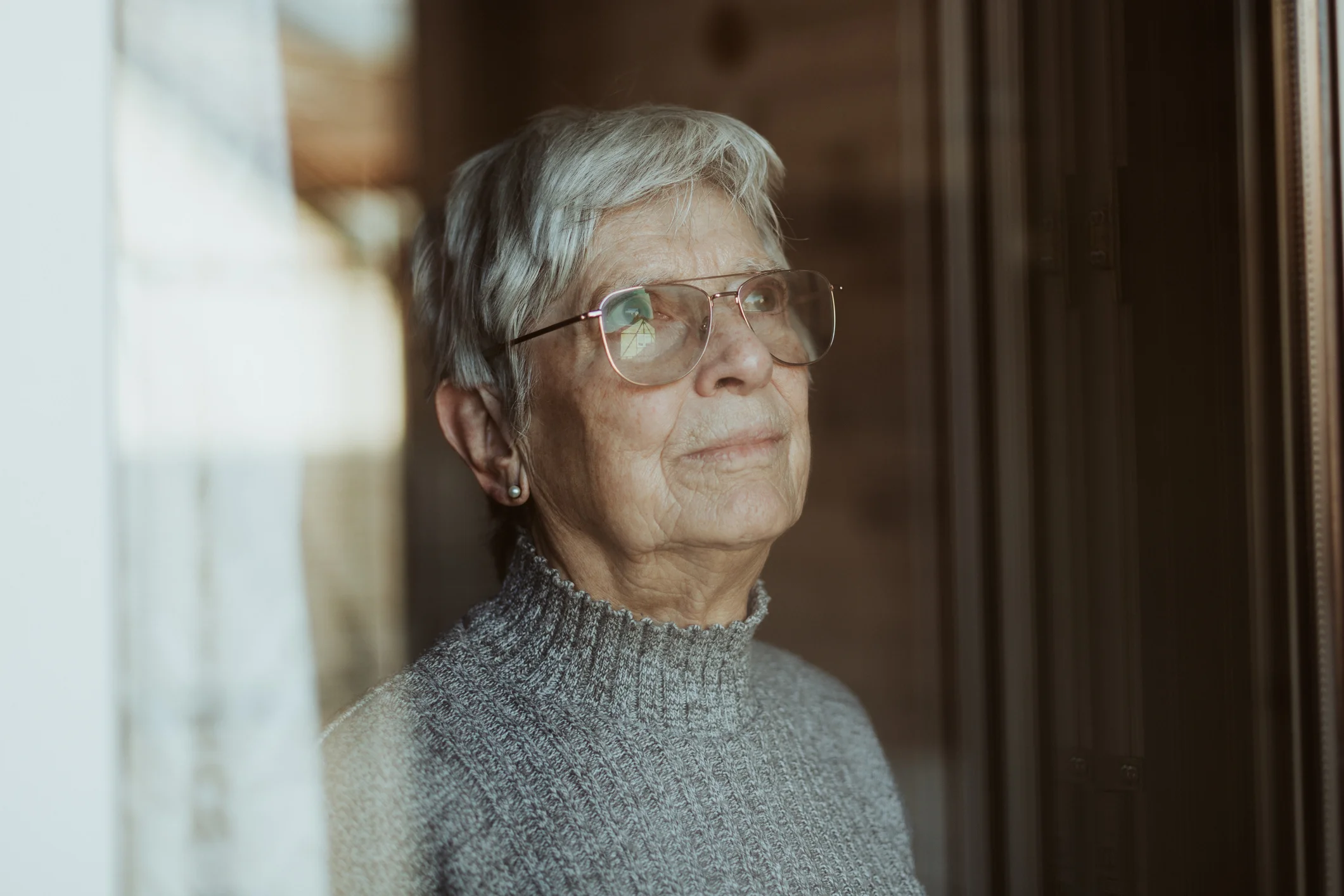 Elderly woman looking out a window